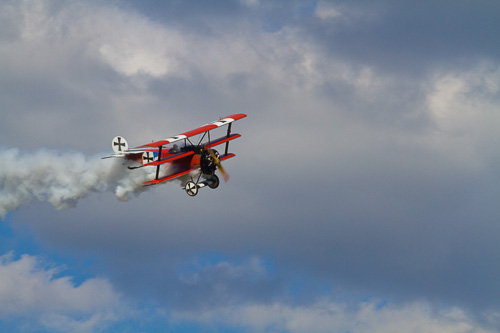 image of a red plane in the blue sky by deb frickanisce